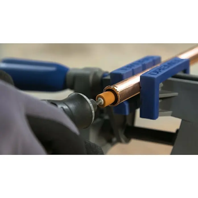 Dremel Multi-Schraubstock 2500Rotationswinkel: 360 °, Neigungswinkel: 50 ° - Eine Nahaufnahme von einem Dremel-Werkzeug, das zum Polieren eines Kupferrohrs verwendet wird, das in einem Schraubstock befestigt ist.