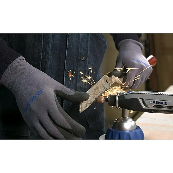Dremel Multi-Schraubstock 2500Rotationswinkel: 360 °, Neigungswinkel: 50 ° - Nahaufnahme einer Person, die mit einem Dremel Lite Multifunktionswerkzeug ein Messer schleift, wobei Funken fliegen.