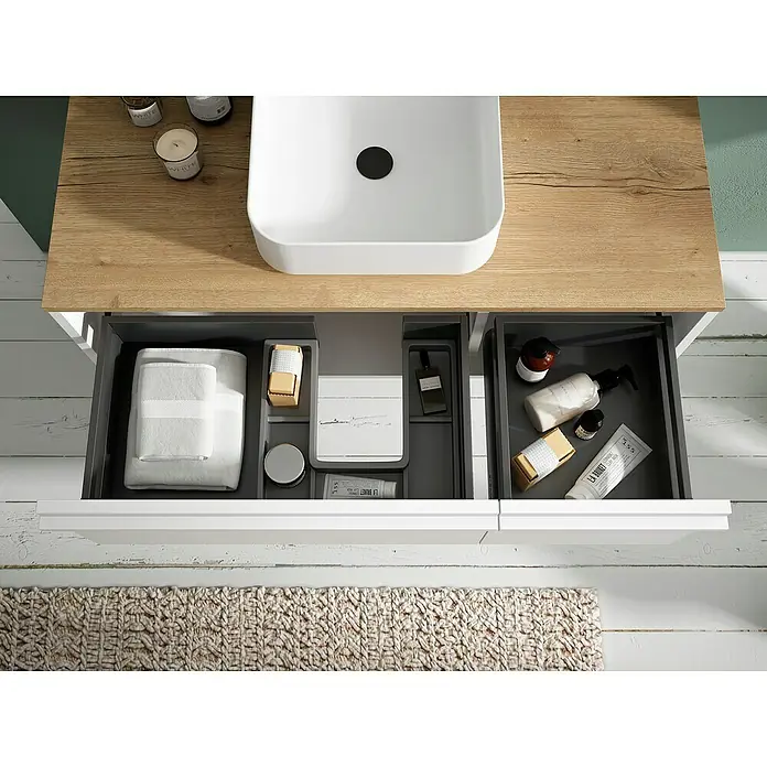 Mueble bajo de lavabo Loira - An x Pr x Al: 80 x 45 x 35 cm, Blanco - Un tocador moderno con cajones abiertos que muestran toallas y artículos de tocador resalta el diseño elegante del baño.