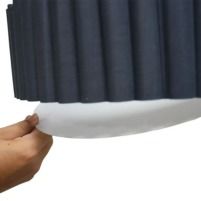 Tween Light Deckenleuchte rund Siena - 160 W, Grau, E14 - Nahaufnahme einer grauen, plissierten Jalousie, die an einer Hand von einem weißen Sockel abgezogen wird.