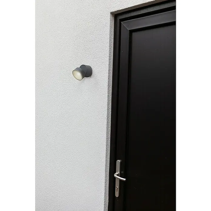 Lutec LED-Außenwandleuchte - 6,7 W, Anthrazit - Nahaufnahme einer an der Wand montierten Außenleuchte neben einer schwarzen Tür, die stilvolle Beleuchtung und Sicherheit bietet.