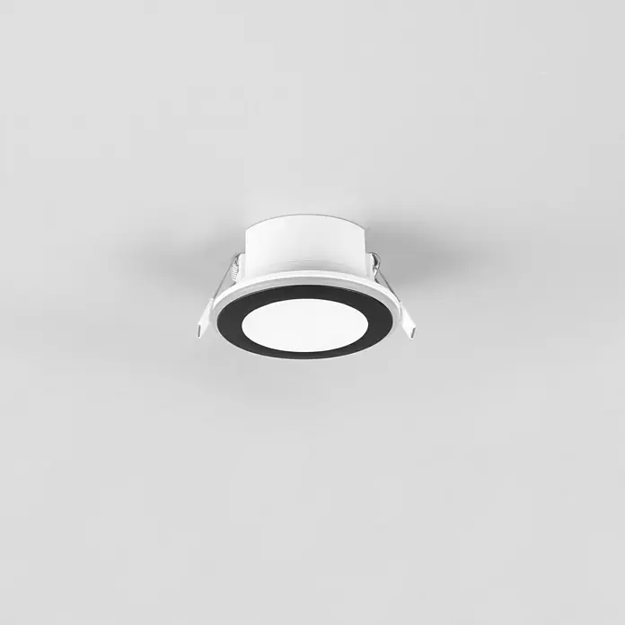 Trio Leuchten LED-Einbauleuchte rund Aura - 5 W, Ø x H: 82 mm x 4 cm, Schwarz - Nahaufnahme einer runden, in die Decke eingelassenen LED-Leuchte mit schwarzem Rand und weißem Licht, die ein modernes Designelement bietet.