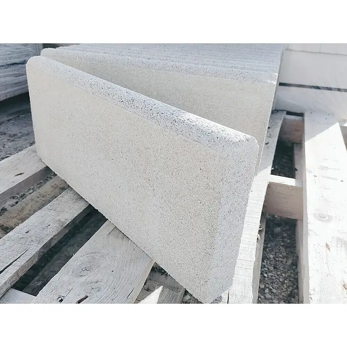 BHS Cataluña Bordillo Redondo - 50 x 5 x 20 cm, Blanco, Hormigón - Primer plano de bordillos grises apilados en un palet de madera, mostrando materiales de construcción para la edificación o el paisajismo.