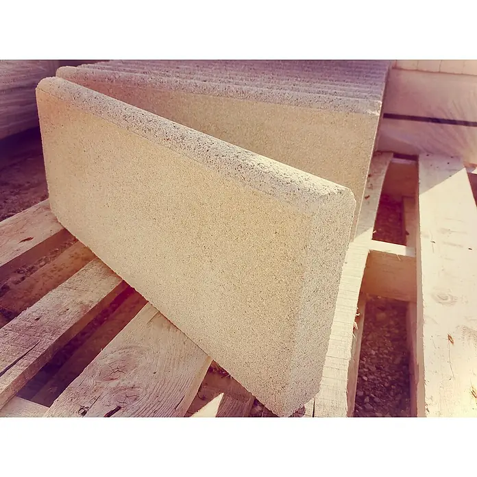 BHS Cataluña Bordillo Redondo - 50 x 5 x 20 cm, Crema, Hormigón - Primer plano de adoquines beige con bordes redondeados, apilados en un palet de madera, ideal para proyectos de jardín y paisajismo.