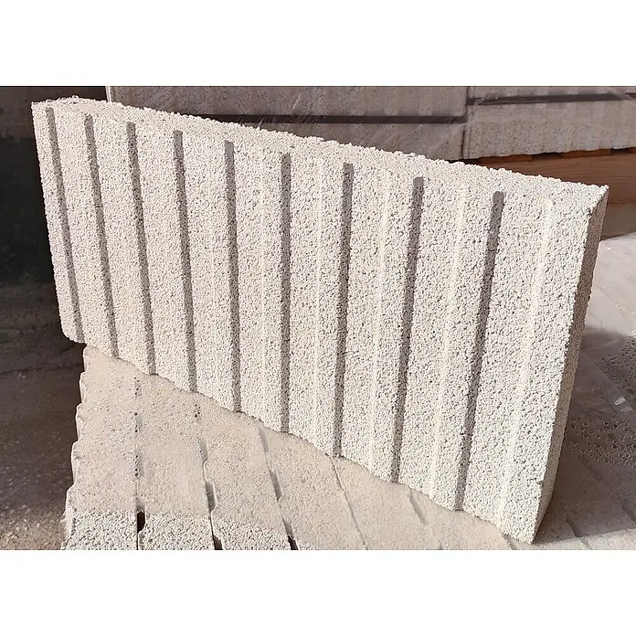 BHS Cataluña Pavimento plaqueta ranurada - 50 x 24,5 cm, Gris - Primer plano de un solo bloque de hormigón celular curado en autoclave (AAC) de color claro y texturizado con ranuras verticales sobre otros bloques.