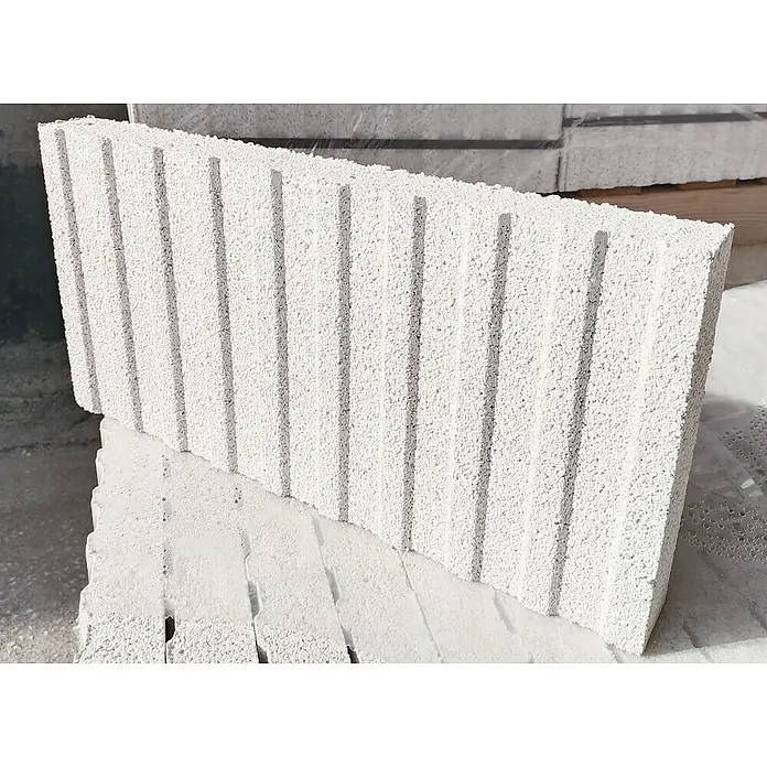 BHS Cataluña Pavimento plaqueta ranurada - 50 x 24,5 cm, Blanco - Primer plano de un bloque de hormigón celular con ranuras verticales, apilado sobre otros bloques. Ideal para proyectos de construcción.