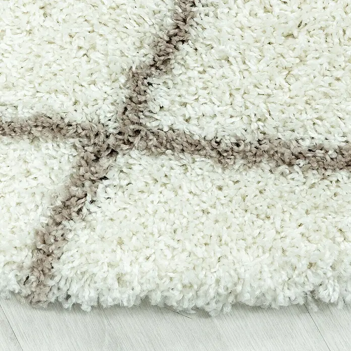 Hochflorteppich Alvor 3401Cream, 370 x 280 cm, 100 % Polypropylen - Nahaufnahme eines weißen Shaggy-Teppichs mit braunen Streifen, der Weichheit und Komfort für jeden Raum verspricht.