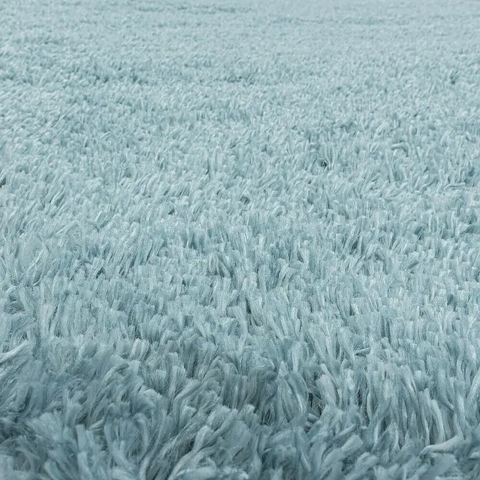 Hochflorteppich Fluffy 3500 - Blau, 200 x 140 cm, 100 % Polypropylen - Nahaufnahme eines weichen, hellblauen Teppichs mit langen Fasern, der eine flauschige Textur und ein beruhigendes Aussehen verleiht.