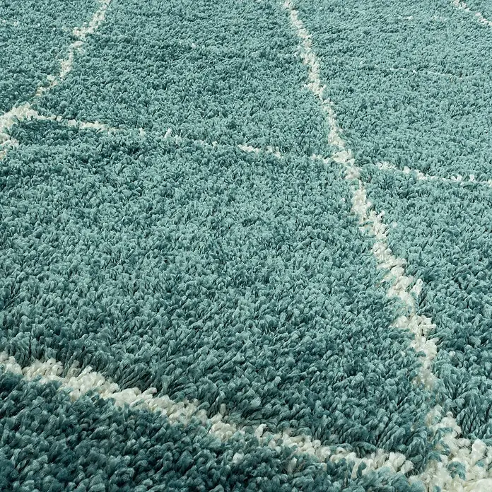Hochflorteppich Alvor 3401Blau, Durchmesser: 200 cm, 100% Polypropylen - Detailaufnahme eines flauschigen, blau-weißen Teppichs mit geometrischem Muster, der Komfort und Stil vereint.