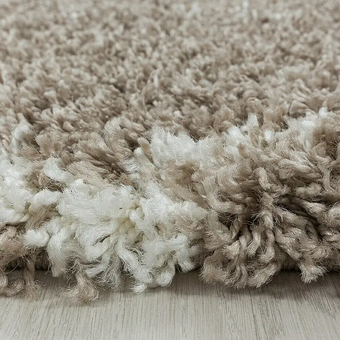 Hochflorteppich Alvor 3401 - Beige, Durchmesser: 80 cm, 100 % Polypropylen - Nahaufnahme eines beigen Teppichs mit weißen Akzenten, der eine weiche und luxuriöse Textur zeigt. Perfekt für gemütliche Wohnräume.