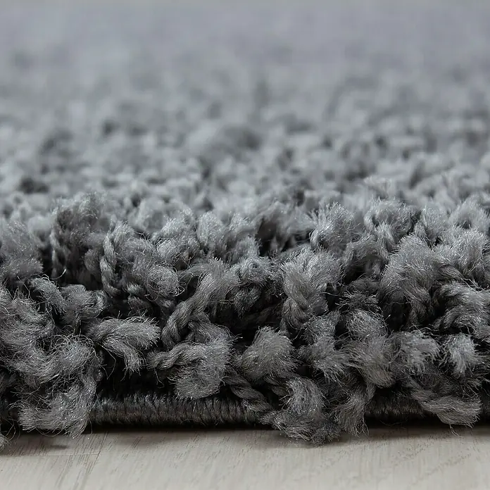 Hochflorteppich Dream 4000Grau, Durchmesser: 80 cm, 100 % Polypropylen - Detailaufnahme eines grauen Shaggy-Teppichs, der eine weiche, flauschige Textur zeigt. Ideal für Wohnräume, die Wärme und Komfort suchen.