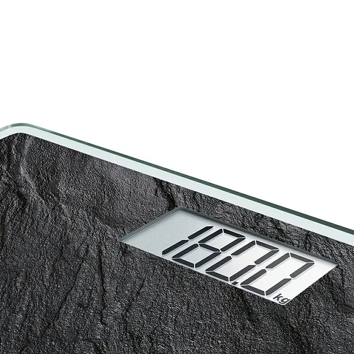 Báscula digital Style Sense Compact 300 - 29 x 29 x 2 cm, Vidrio, Negro pizarra - Primer plano de una báscula de baño digital con superficie de piedra que muestra un peso de 180.0 kg.