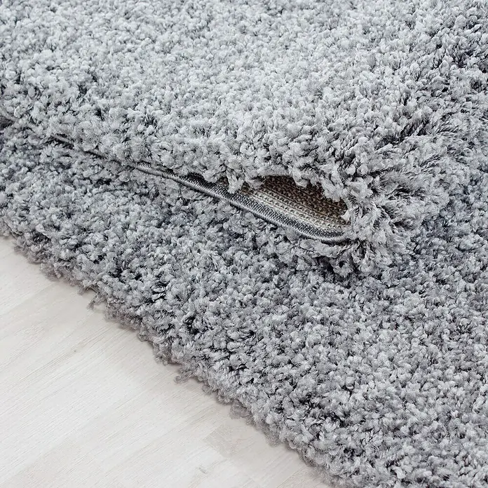 Hochflorteppich Life 1500 - Light Grey, 110 x 60 cm, 100 % Polypropylen - Nahaufnahme eines grauen, zotteligen Teppichs, der die weiche Textur und dicke Fasern hervorhebt. Ideal für Wohnräume und Schlafzimmer.