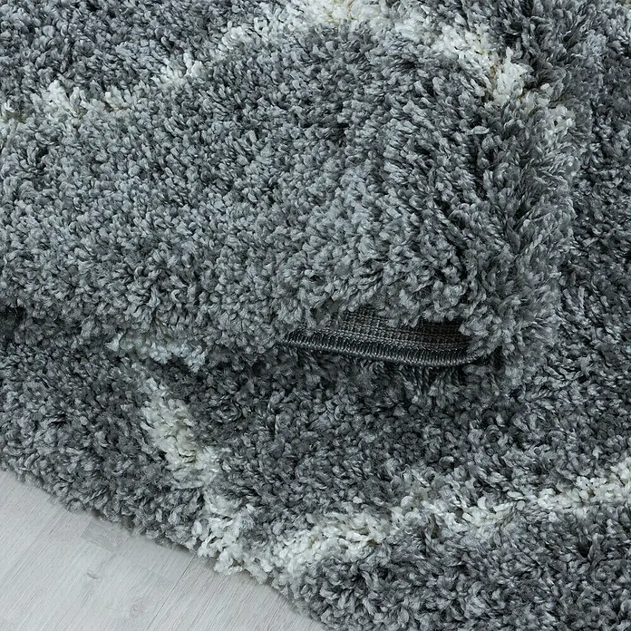 Hochflorteppich Alvor 3401Grau, 370 x 280 cm, 100 % Polypropylen - Detailaufnahme eines grauen Hochflorteppichs mit weißen Akzenten, der eine weiche und einladende Textur zeigt.