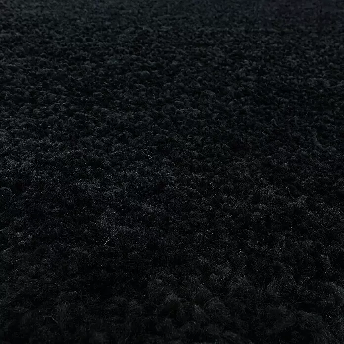 Hochflorteppich Sydney 3000 - Schwarz, 110 x 60 cm, 100% Polypropylen - Nahaufnahme einer schwarzen zotteligen Kunstfelltextur.