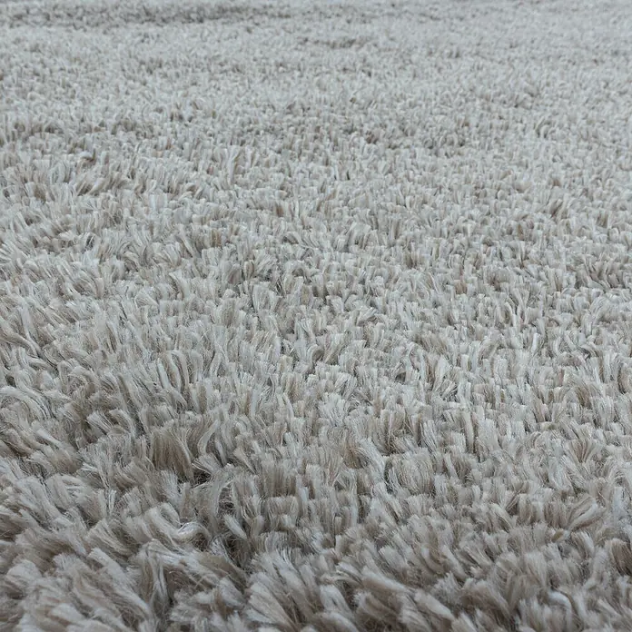 Hochflorteppich Fluffy 3500 - Beige, 370 x 280 cm, 100 % Polypropylen - Nahaufnahme eines beigen, hochflorigen Teppichs, der eine weiche und komfortable Textur zeigt.\n
