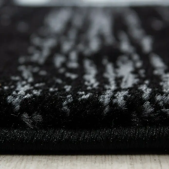 Kurzflorteppich Miami - Schwarz/Weiß, 340 x 240 cm, 100 % Polypropylen - Nahaufnahme eines Teppichs mit abstraktem Muster in Schwarz- und Grautönen, der eine weiche Textur und ein modernes Design zeigt.