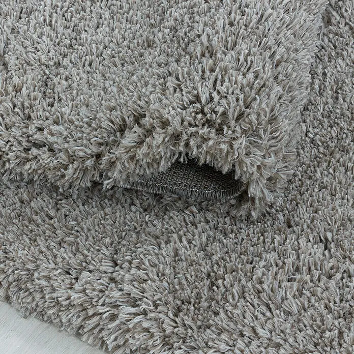 Hochflorteppich Fluffy 3500 - Beige, 370 x 280 cm, 100 % Polypropylen - Nahaufnahme eines gewundenen, flauschigen Teppichs in sanften Grautönen, der Komfort und Textur vermittelt. Perfekt für ein gemütliches Zuhause.