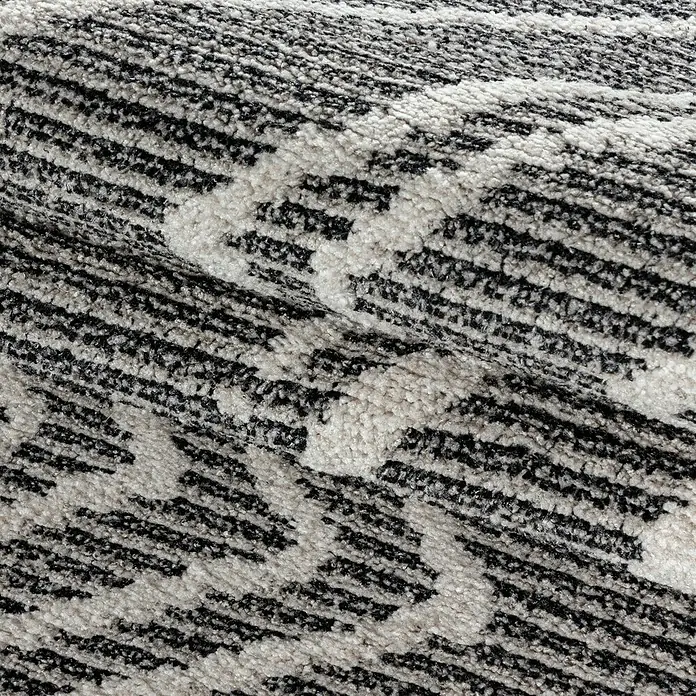 Kurzflorteppich Taznaxt 5104 - Schwarz, 200 x 140 cm, 100% Polyester - Nahaufnahme eines strukturierten Teppichs in Schwarz und Weiß mit abstraktem Muster.