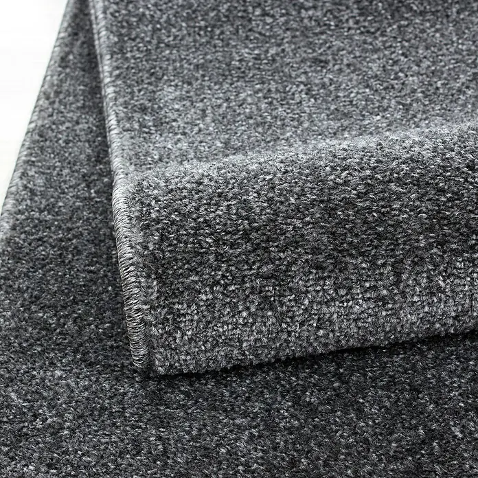 Kurzflorteppich Ata 7000Grau, 230 x 160 cm, 100 % Polypropylen - Nahaufnahme eines grauen Teppichs, der die Textur und die Verarbeitung des Teppichs hervorhebt. Ideal für die Darstellung von Teppichdetails.