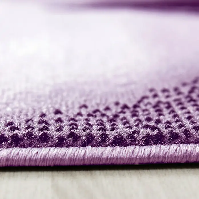 Kurzflorteppich Plus 8008 - Lila, 290 x 200 cm, 100% Polypropylen - Nahaufnahme eines lila Teppichs mit dekorativem Muster und eingefassten Kanten, ideal für gemütliche Wohnräume und moderne Dekoration.