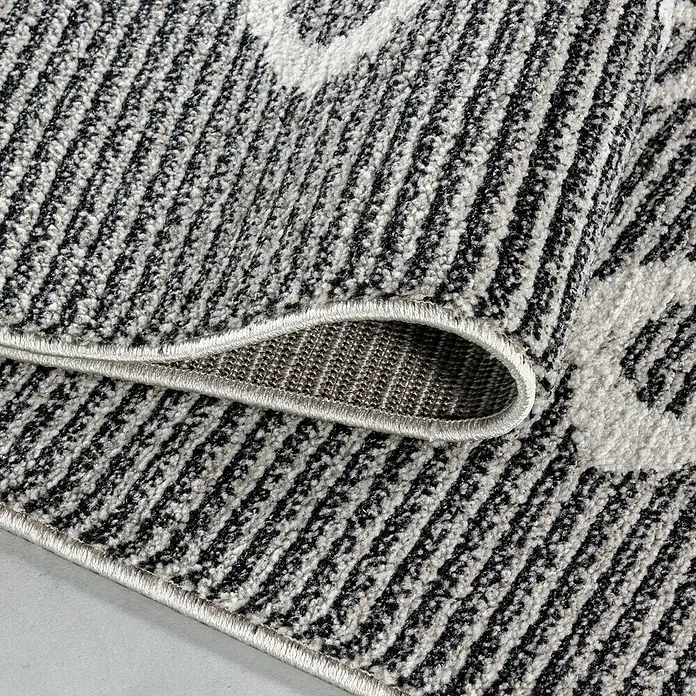Kurzflorteppich Taznaxt 5104Schwarz, 250 x 80 cm, 100% Polyester - Detailansicht eines modernen Teppichs mit abstraktem Muster in Schwarz, Weiß und Grau. Die Textur und Verarbeitung sind gut sichtbar.