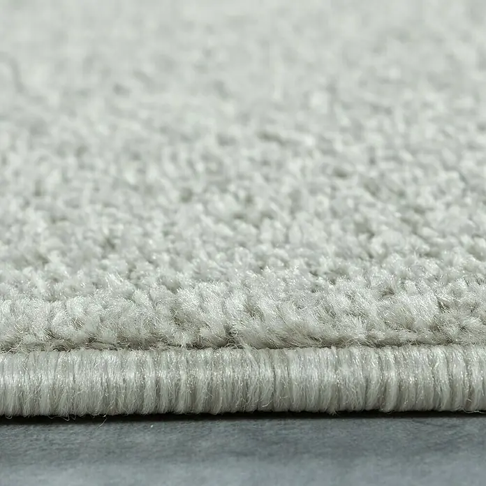 Kurzflorteppich Ata 7000Cream, 150 x 80 cm, 100 % Polypropylen - Nahaufnahme eines hellgrauen Teppichs, der die weiche Textur und die dichte Verarbeitung betont. Ideal für ein gemütliches Zuhause.