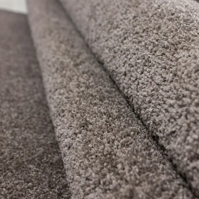 Kurzflorteppich Ata 7000 - Mocca, 200 x 140 cm, 100% Polypropylen - Nahaufnahme eines grauen Teppichs. Die Textur des Teppichs ist gut sichtbar. Ideal für Wohnräume, Schlafzimmer oder Büros.