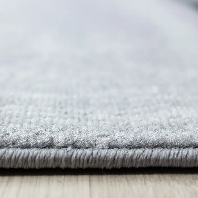 Kurzflorteppich Plus - Anthrazit, 370 x 280 cm, 100 % Polypropylen - Nahaufnahme eines grauen Teppichs, der die Textur und die Kante des Teppichs hervorhebt.