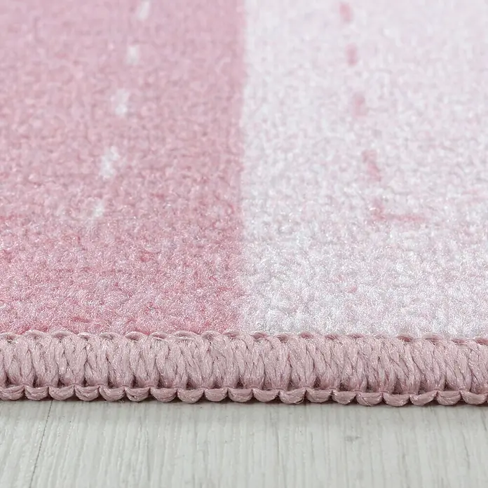 Kinderteppich Play 2905Pink, 200 x 140 cm, 100% Polyamide - Detailaufnahme eines rosa Teppichs mit eingefasstem Rand und hellen Farbverläufen.