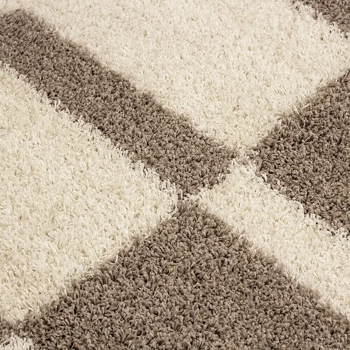 Hochflorteppich Gala 2505Beige, 250 x 80 cm, 100% Polypropylen - Nahaufnahme eines hochflorigen Teppichs mit geometrischem Muster in Creme und Grau, der eine weiche Textur und modernes Design zeigt.