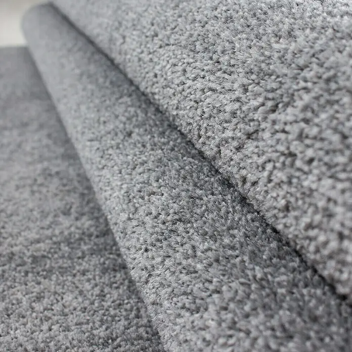 Kurzflorteppich Ata 7000 - Light Grey, 200 x 140 cm, 100 % Polypropylen - Detailaufnahme eines grauen Teppichs. Die weiche Textur und die gewebte Struktur sind gut erkennbar.