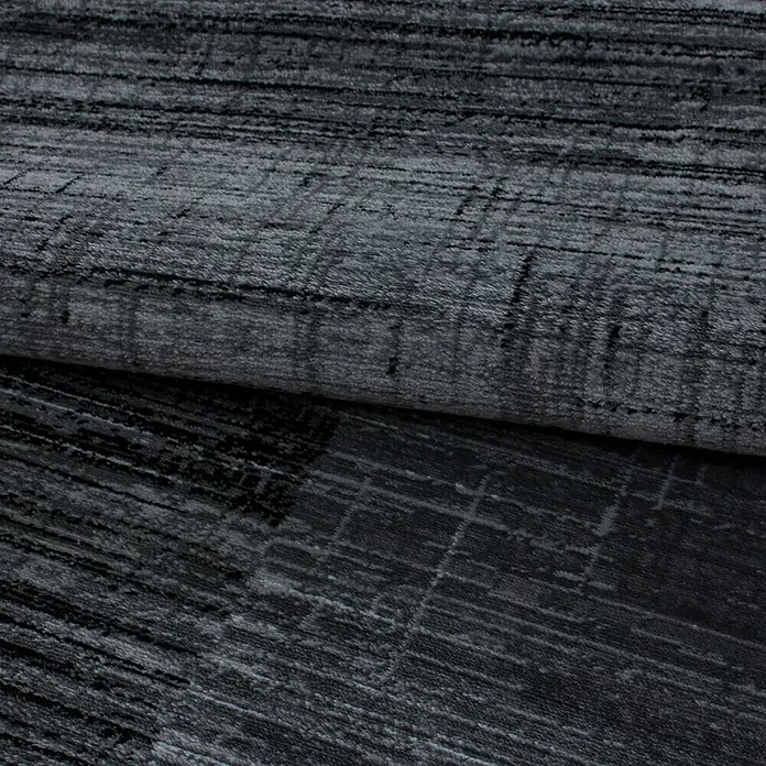 Kurzflorteppich Plus 8001Schwarz, 230 x 160 cm, 100% Polypropylen - Detailaufnahme eines grauen Teppichs mit abstrakten Linien und Textur. Ideal für moderne Wohnräume und zur Ergänzung stilvoller Einrichtungen.