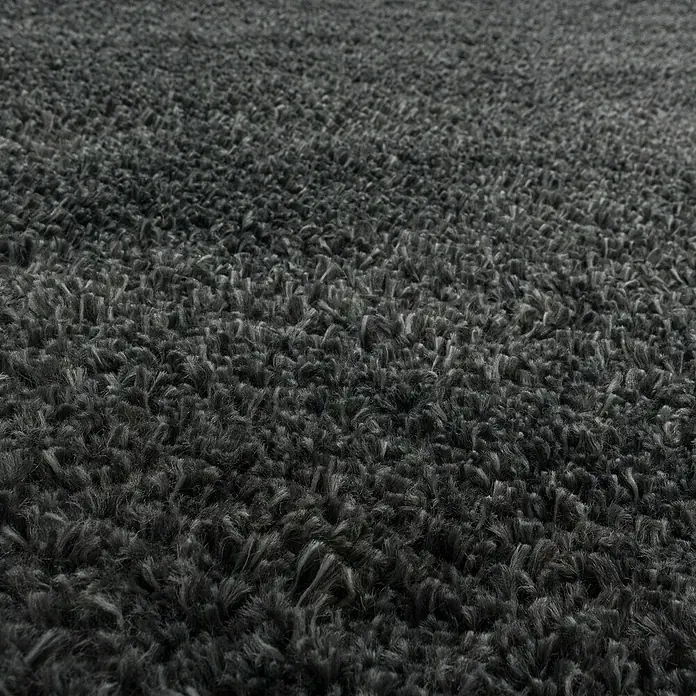 Hochflorteppich Fluffy 3500 - Grau, 170 x 120 cm, 100 % Polypropylen - Detailaufnahme eines flauschigen, anthrazitfarbenen Teppichs, der Weichheit und Komfort ausstrahlt. Perfekt, um jedem Raum Wärme und Textur zu verleihen.