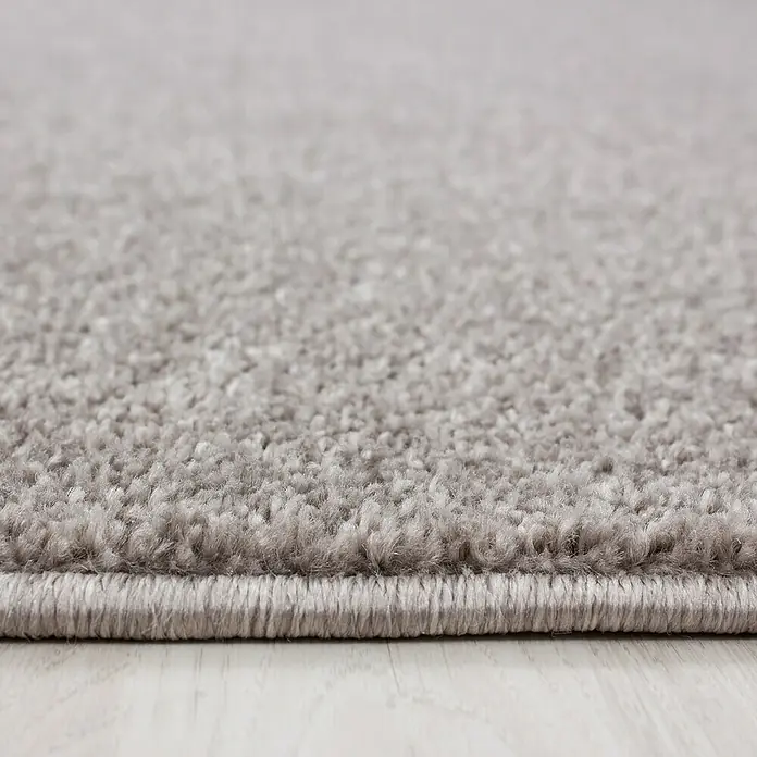 Kurzflorteppich Ata 7000 - Beige, 250 x 80 cm, 100 % Polypropylen - Nahaufnahme eines grauen Teppichs mit weicher Textur und sauberer Kante, ideal für ein gemütliches Zuhause.