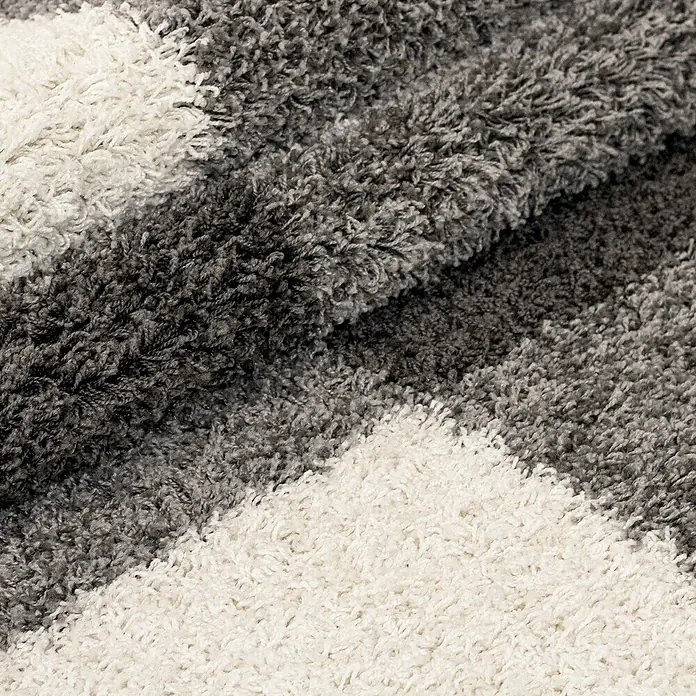 Hochflorteppich Gala 2505Light Grey, 110 x 60 cm, 100% Polypropylen - Nahaufnahme eines grau-weißen Teppichs mit hochflorigem Flor, der eine weiche und gemütliche Textur zeigt.