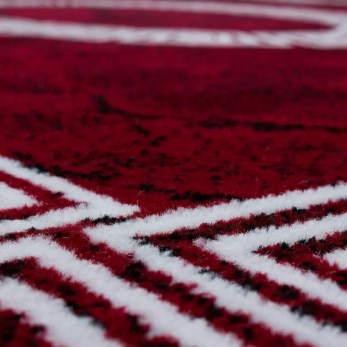 Kurzflorteppich Plus 8009Rot, 300 x 80 cm, 100% Polypropylen - Nahaufnahme eines roten Teppichs mit weißen Streifen, der Textur und Muster hervorhebt.