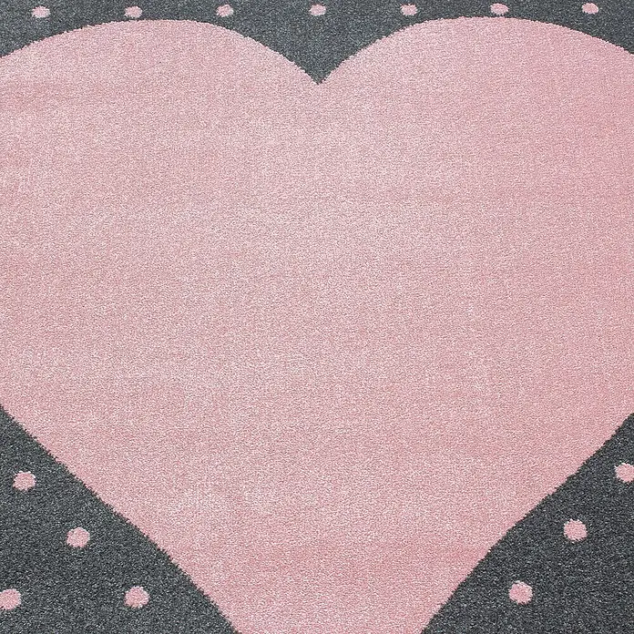 Kinderteppich Bambi 0830Pink, 150 x 80 cm, 100 % Polypropylen - Nahaufnahme eines herzförmigen Teppichs mit rosa Herz und grauem Rand mit Punkten, ideal für Kinderzimmer.
