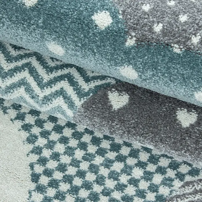 Kinderteppich Bambi 0820 - Blau, 170 x 120 cm, 100 % Polypropylen - Detailansicht eines weichen Teppichs mit verschiedenen Mustern in Grau- und Blautönen, ideal für Kinderzimmer oder Wohnbereiche.