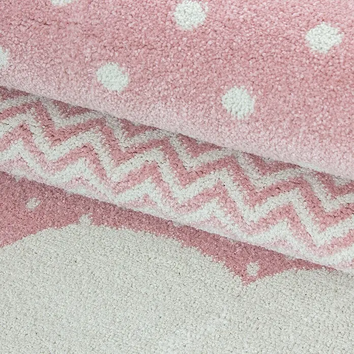 Kinderteppich Bambi 0820 - Pink, Durchmesser: 160 cm, 100 % Polypropylen - Nahaufnahme eines pinkfarbenen Teppichs mit weißen Punkten, Zickzackmuster und gezacktem Rand, der eine verspielte und dekorative Note verleiht.