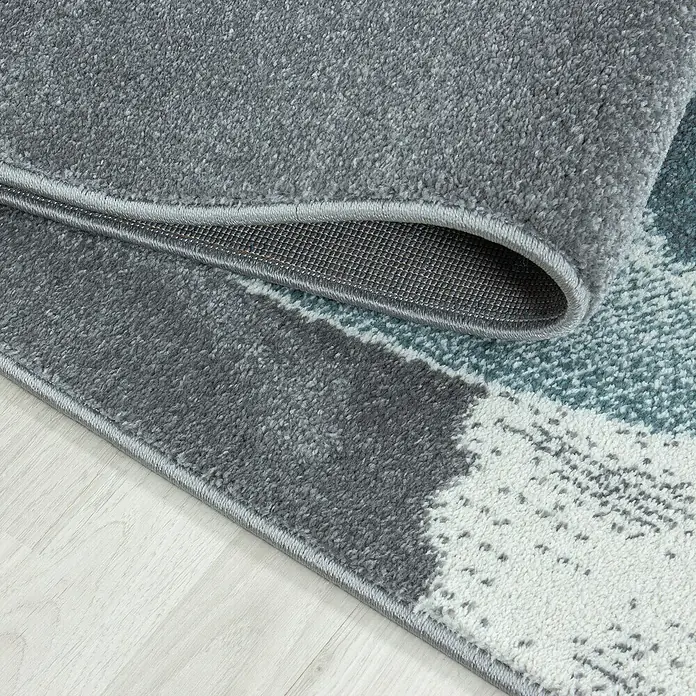 Kinderteppich Bambi 0840 - Blau, 290 x 200 cm, 100 % Polypropylen - Detailaufnahme eines modernen grauen Teppichs mit abstraktem Muster, der eine weiche Textur und hochwertige Verarbeitung zeigt.