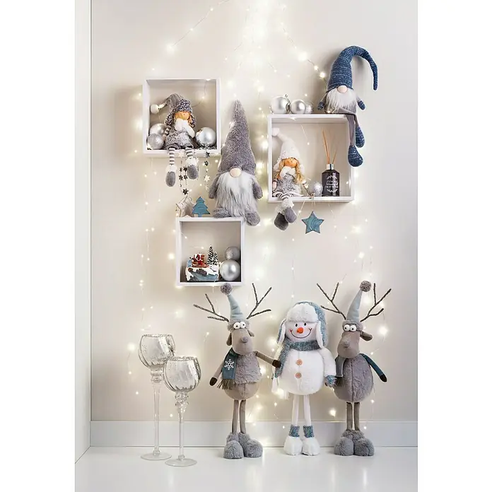 Figura decorativa Lapua - Textil - Decoración navideña con muñecos de peluche, estantes, adornos y luces, creando un ambiente festivo y acogedor.