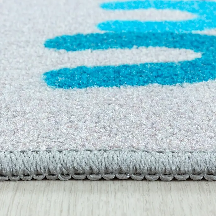 Kinderteppich Play 2904 - Grau, 150 x 100 cm, 100% Polyamide - Nahaufnahme eines Teppichs mit blauen Streifen auf einem hellgrauen Untergrund, der eine weiche Textur und eine saubere, graue Bordüre aufweist.