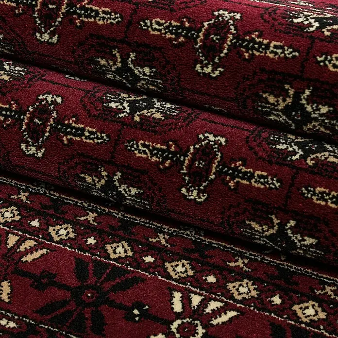 Kurzflorteppich Orient-Optik Marrakesh 0351 - Rot, 170 x 120 cm, 100% Polypropylen - Nahaufnahme eines detailreichen, dunkelroten Teppichs mit traditionellen, schwarzen und beigen Mustern für eine gemütliche Atmosphäre.