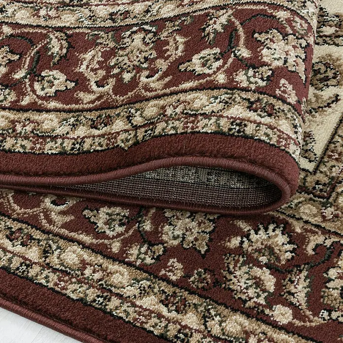 Kurzflorteppich Kashmir 2604Cream, 150 x 80 cm, 100% Polypropylen - Nahaufnahme eines eleganten, gewundenen Teppichs mit einem detaillierten floralen Muster und einer satten, warmen Farbpalette.