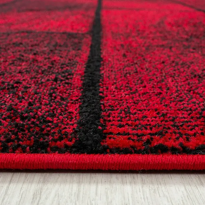 Kurzflorteppich Beta 1110 - Rot, 290 x 200 cm, 100 % Polypropylen - Nahaufnahme eines rot-schwarzen Teppichs mit einem modernen Karomuster. Der Teppich hat eine fein gewebte Textur und eine rote Umrandung.