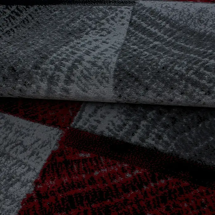 Kurzflorteppich Plus - Rot/Grau, 340 x 240 cm, 100 % Polypropylen - Nahaufnahme eines modernen Teppichs mit geometrischen Mustern in Grau- und Rottönen. Das Design verleiht jedem Raum einen stilvollen Akzent.