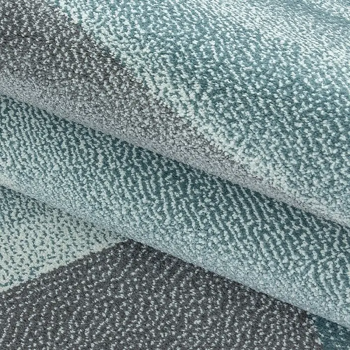 Kurzflorteppich Beta 1130 - Blau, 230 x 160 cm, 100 % Polypropylen - Nahaufnahme eines stilvollen Teppichs mit geometrischem Muster in Grau- und Blautönen, der eine moderne und komfortable Atmosphäre ausstrahlt.