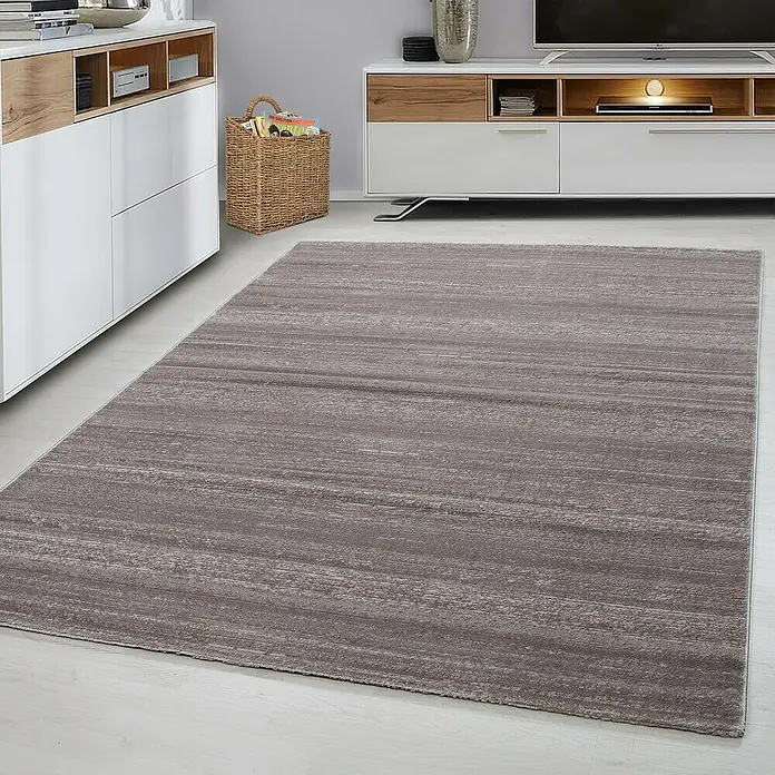 Kurzflorteppich Plus 8000Beige, 150 x 80 cm, 100% Polypropylen - Ein rechteckiger Teppich in einem warmen Grauton mit subtilen horizontalen Streifen liegt in einem modern eingerichteten Wohnzimmer.