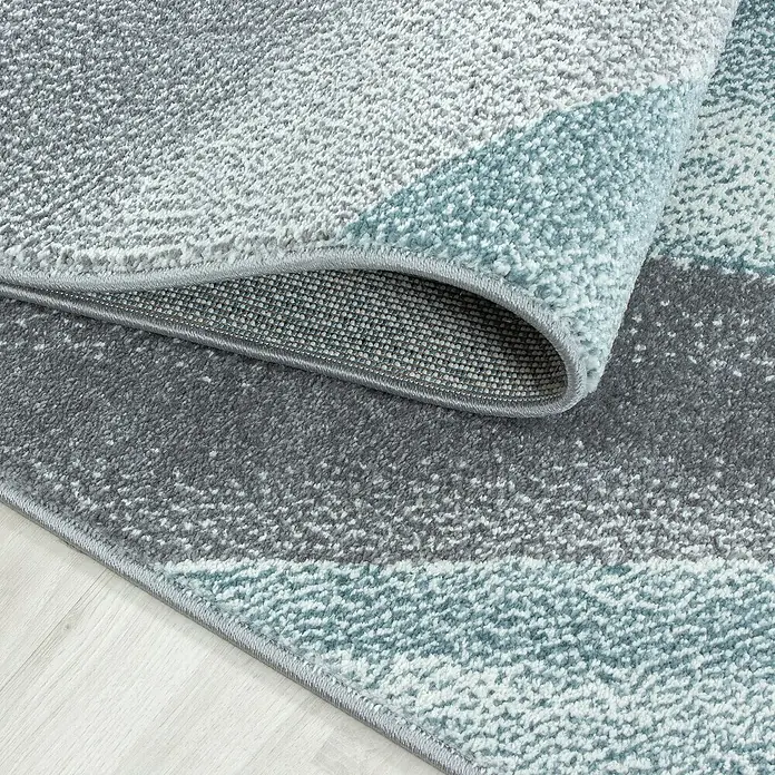 Kurzflorteppich Beta 1130Blau, 230 x 160 cm, 100 % Polypropylen - Detailaufnahme eines modernen Teppichs mit geometrischem Muster in Grau- und Blautönen, der eine stilvolle und komfortable Ergänzung für jeden Raum darstellt.